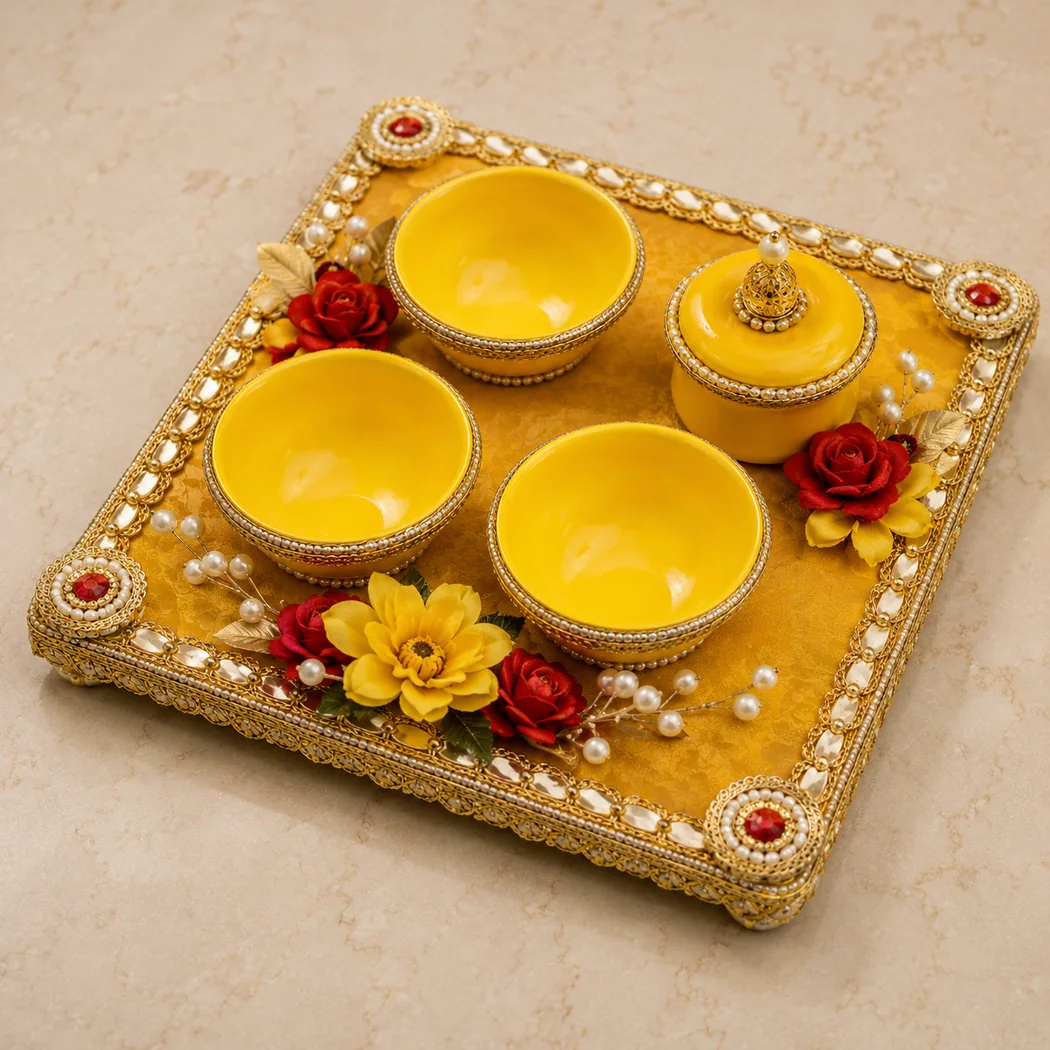 Yellow haldi bowls arranged on a decorated traditional tray